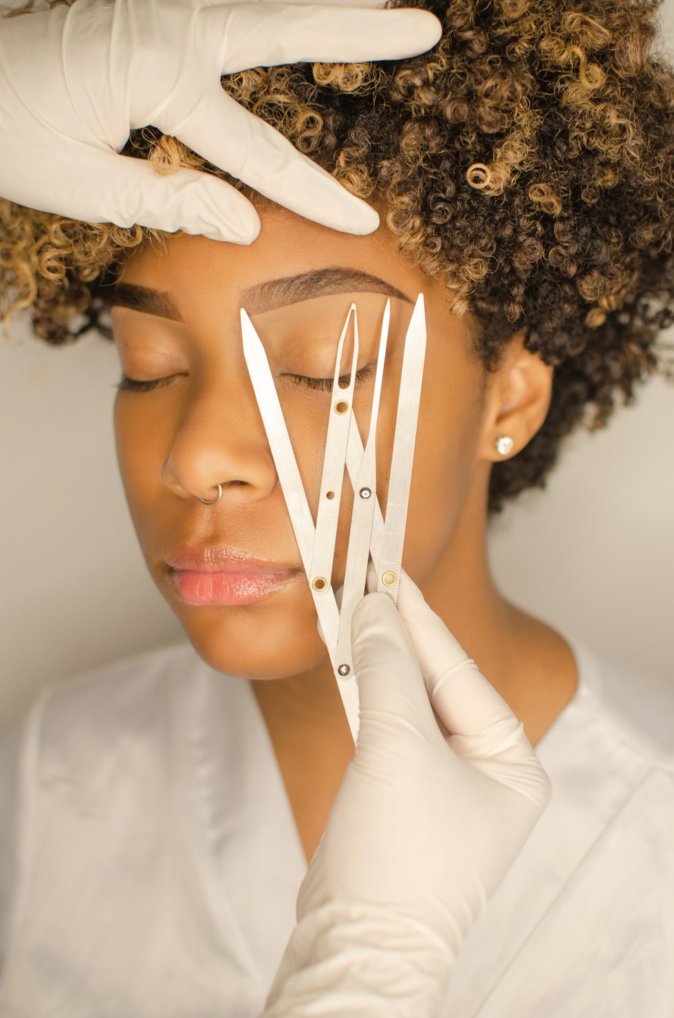 Beautician is measuring the brows